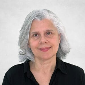 Beverly Wasmund is a middled-aged woman with shoulder-length grey hair. She is wearing a black button-up shirt.