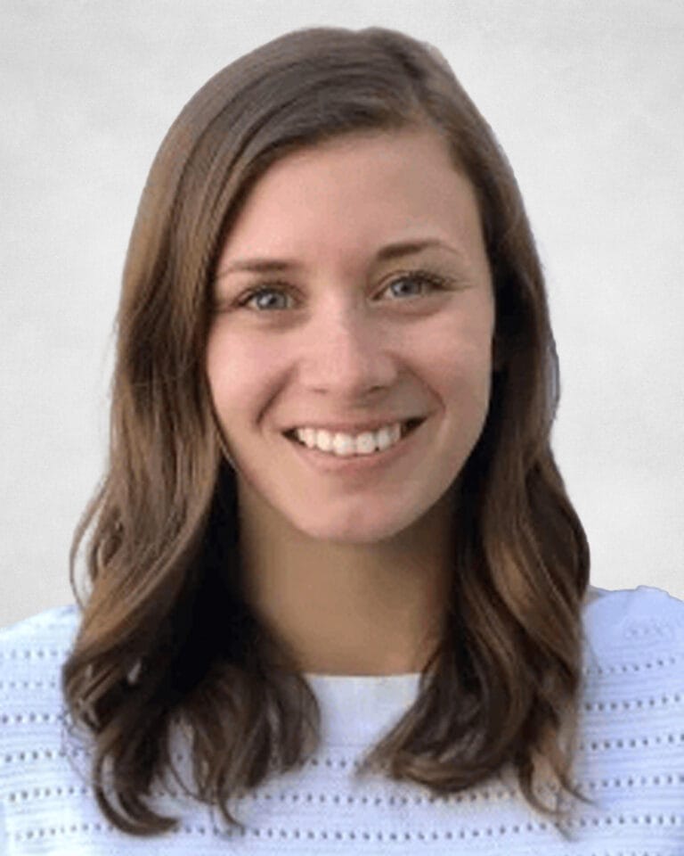 Chelsea Del Begio is a woman with long brown hair and blue eyes. She is wearing a white textured blouse.