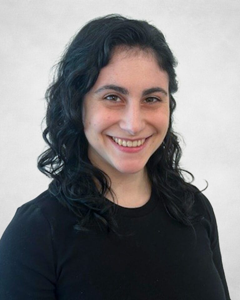 Daniela Luongo is a woman with wavy dark hair and is wearing a black top.