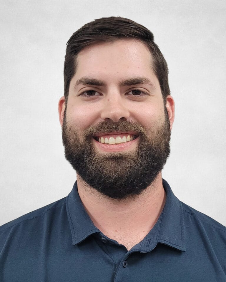 Mike Askew is a man with short dark hair and a full beard. He is wearing a dark blue collared shirt.